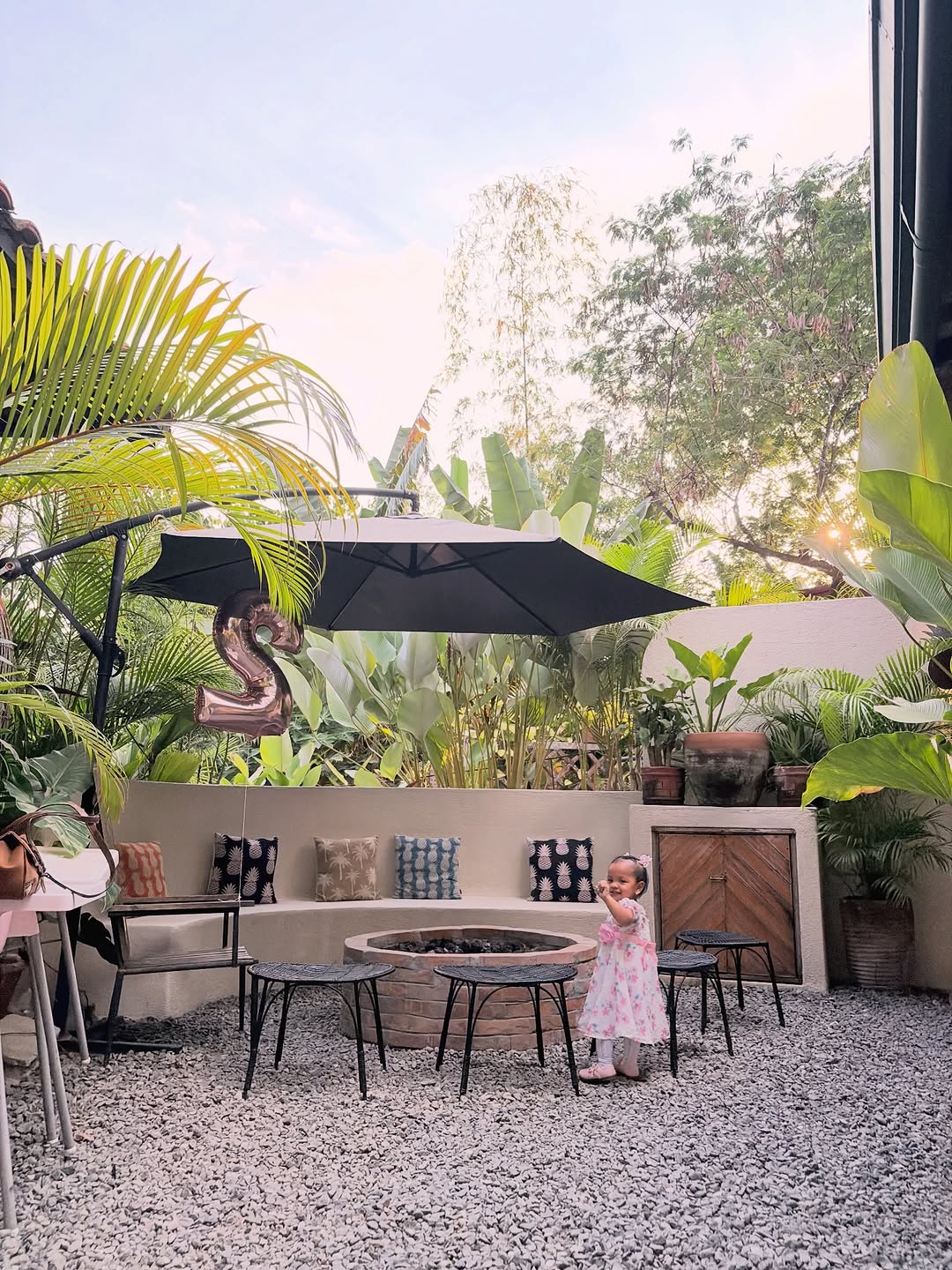 PIÑA outdoor seating area with umbrella and tropical plants